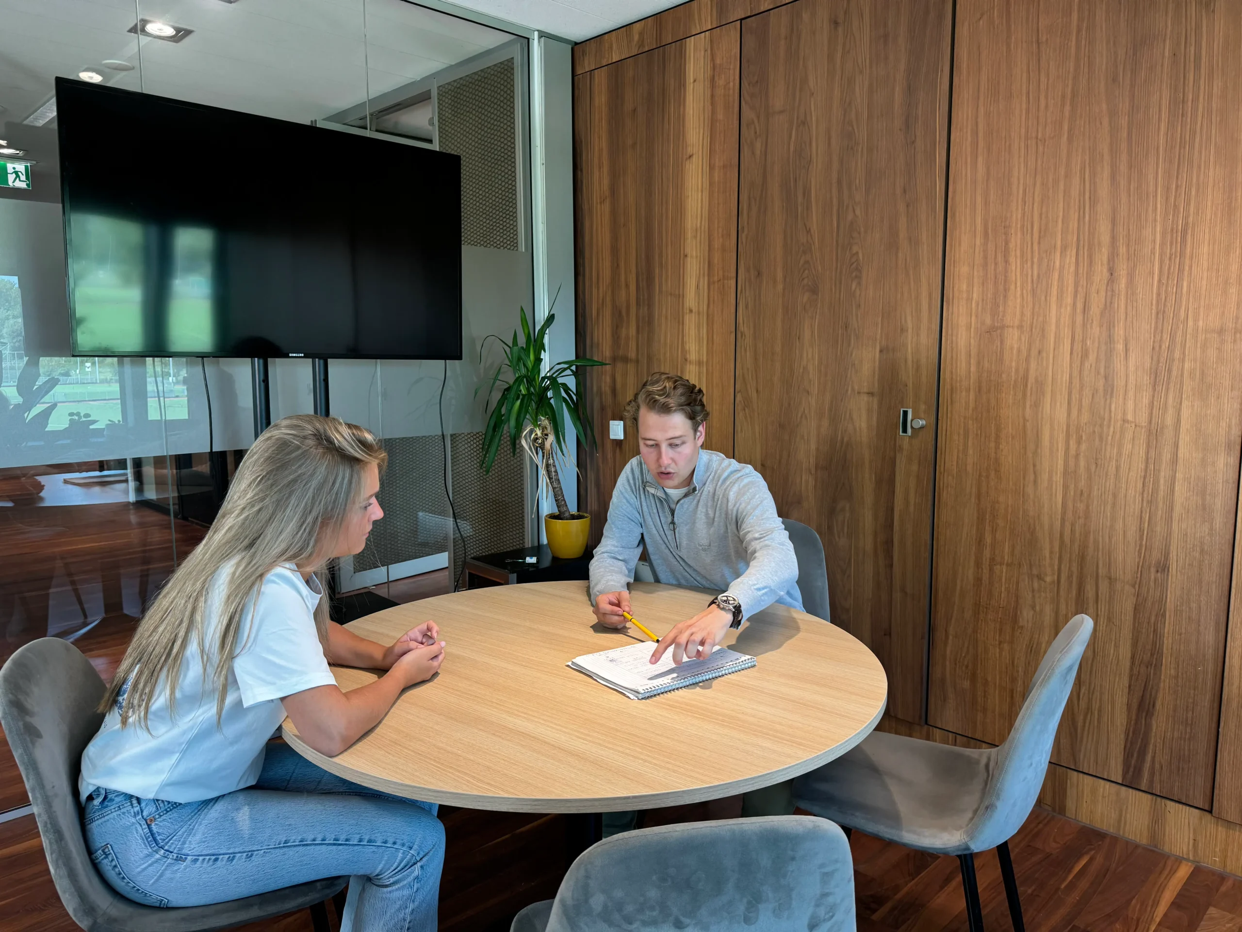 Onze projectleider in overleg met een medewerker van een kliniek over social media strategie