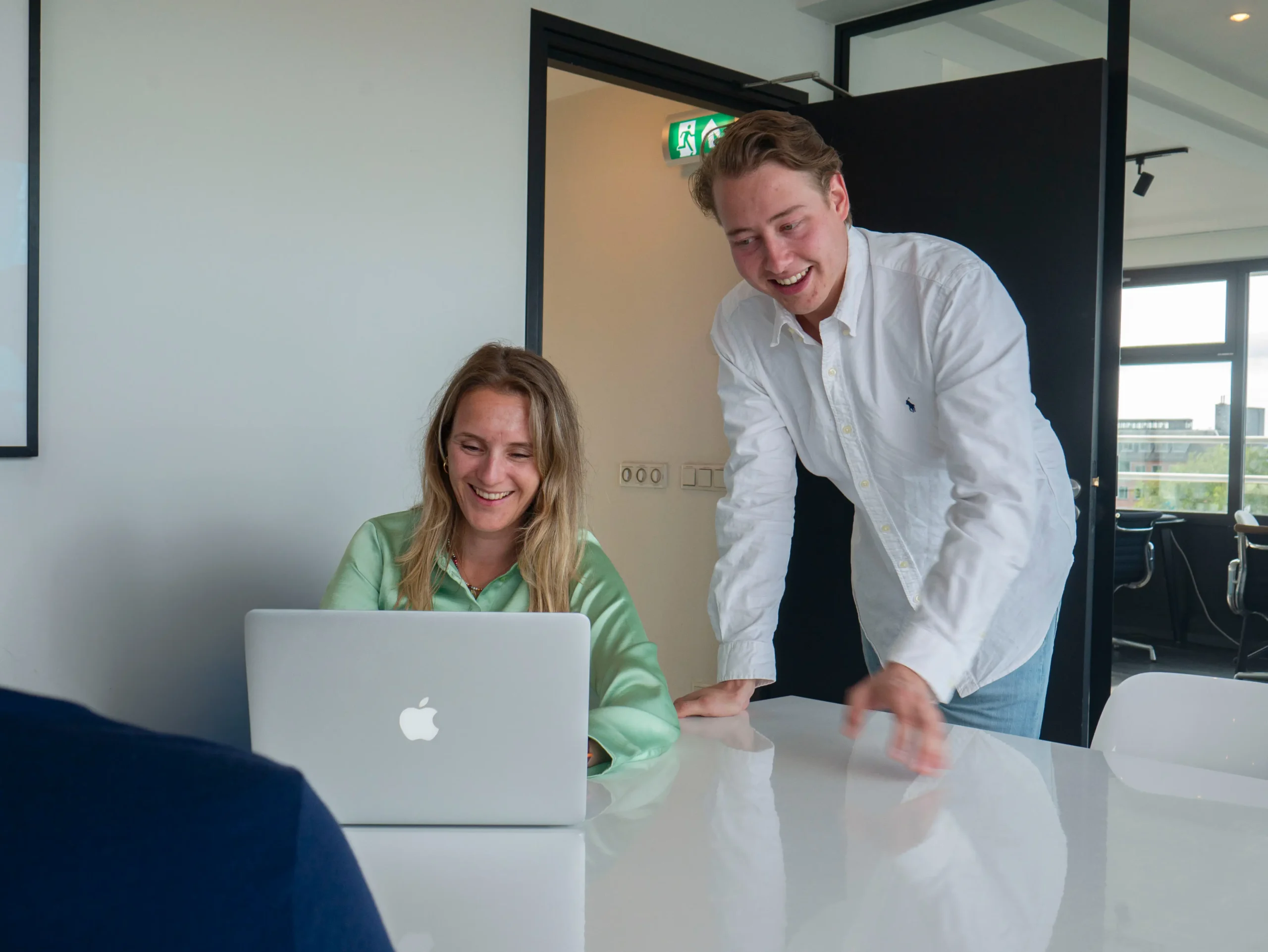 Onze projectleider kijkt mee met een medewerker en bespreekt resultaten op het scherm